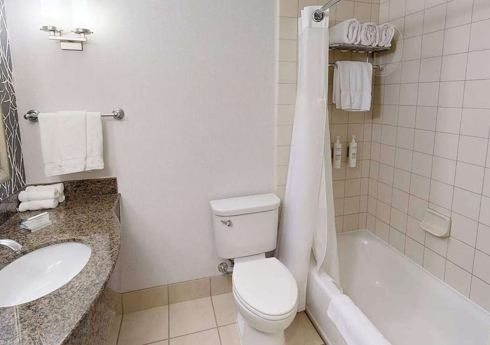 Clean bathroom with tub, shower curtain, and fresh towels