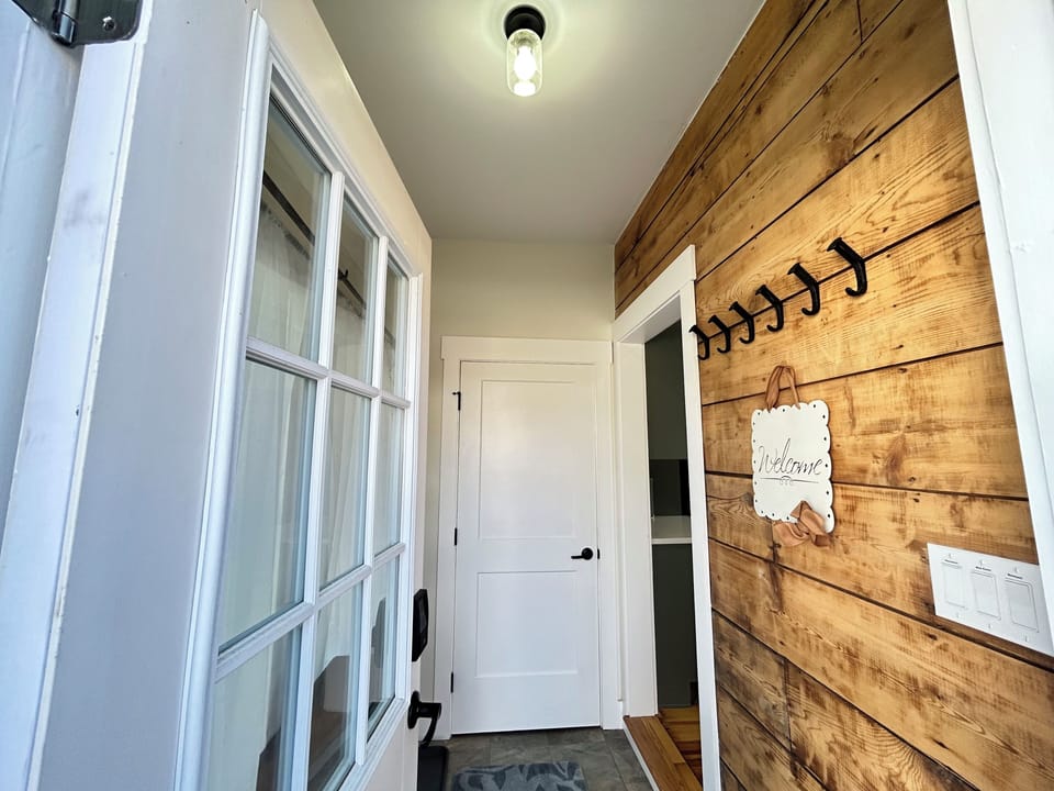 Mudroom entrance from parking area. Hooks for coats, Drop zone.