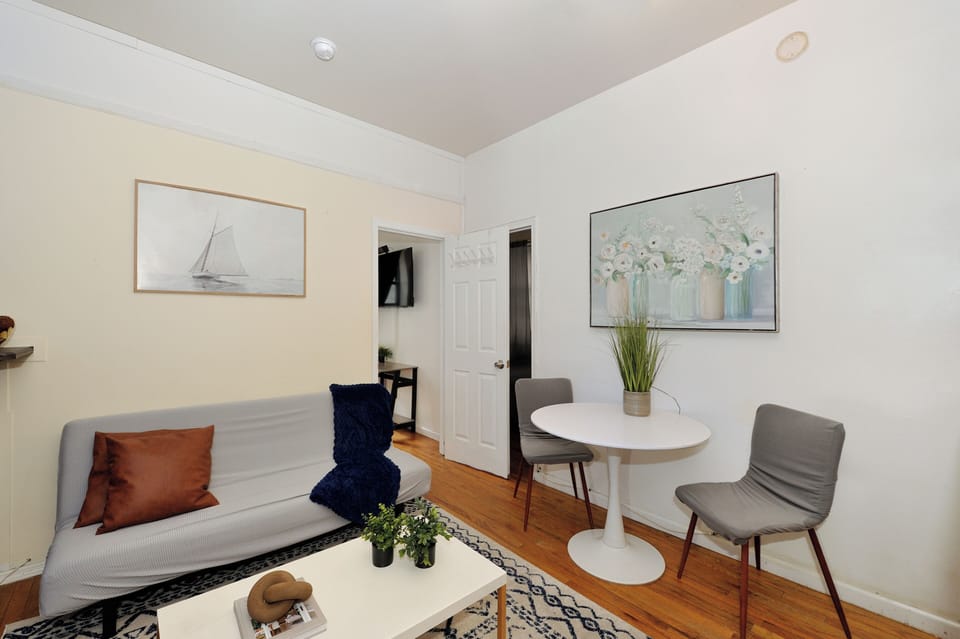 Relax in your bright living room with cozy seating and dining area, perfectly styled for intimate meals and quiet evenings.