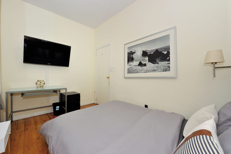 Rest peacefully in your bright, airy bedroom featuring a flat-screen TV and coastal artwork for a serene retreat.