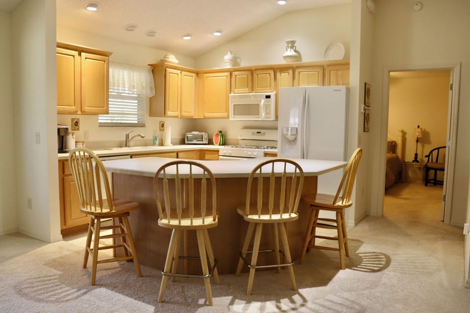 Your fully equipped kitchen features warm wood cabinetry, modern appliances, and an inviting island where you can gather for meals.