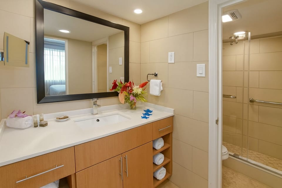 Refresh at the sleek vanity with bright lighting and fresh towels.
