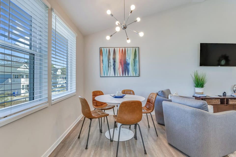 Modern dining space with stylish chandelier and street views perfect for morning coffee or evening meals with your group.