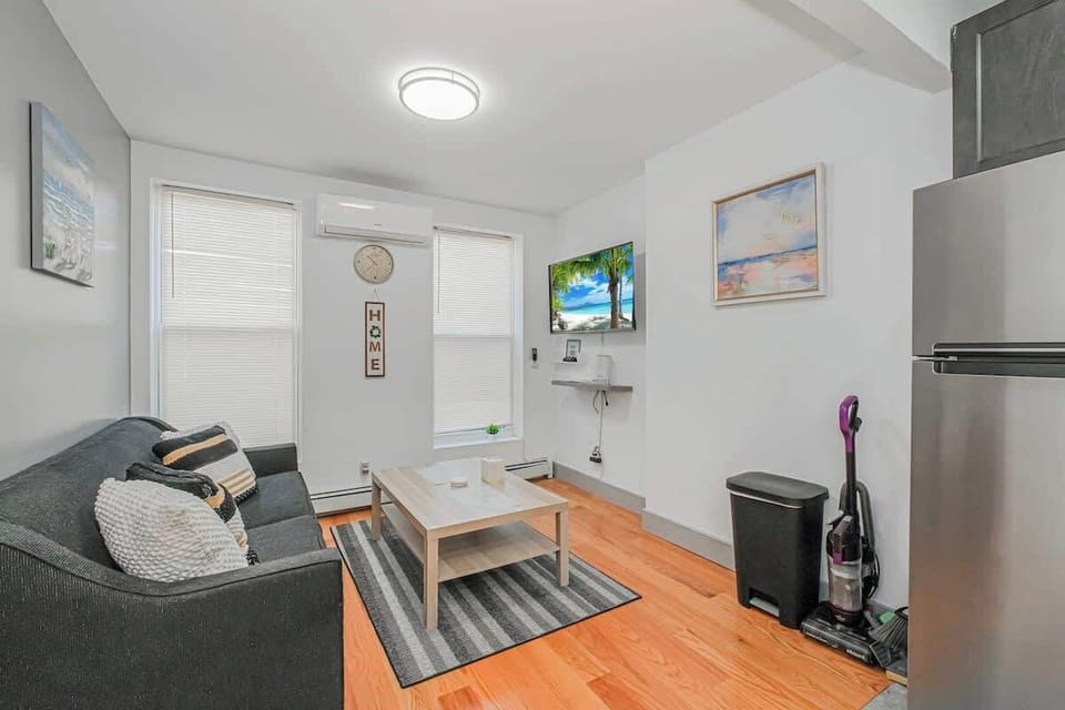 Modern living room featuring a comfortable dark sofa, flat-screen TV, and stylish décor.