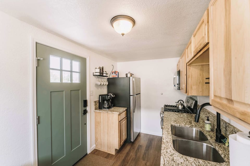 View into the kitchen from the entry, highlighting the efficient layout, warm wood cabinetry, and well-organized cooking space that makes everyday meals easy.