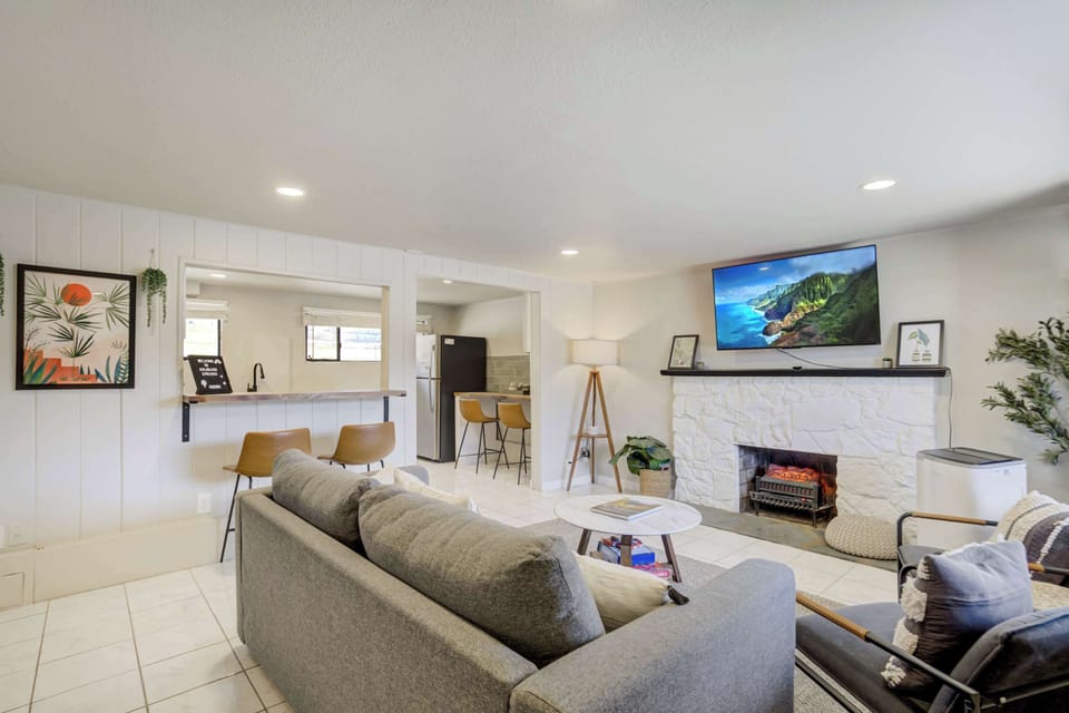 Relaxing seating area centered around the fireplace, with natural light coming through the large window for a bright, inviting feel.
