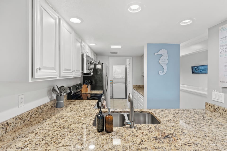 Close-up of the kitchen sink and granite breakfast bar area.