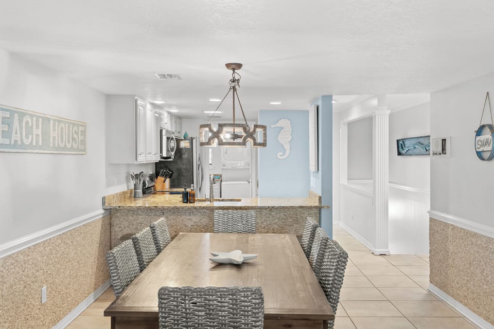 Dining space featuring a modern chandelier and views into the kitchen.