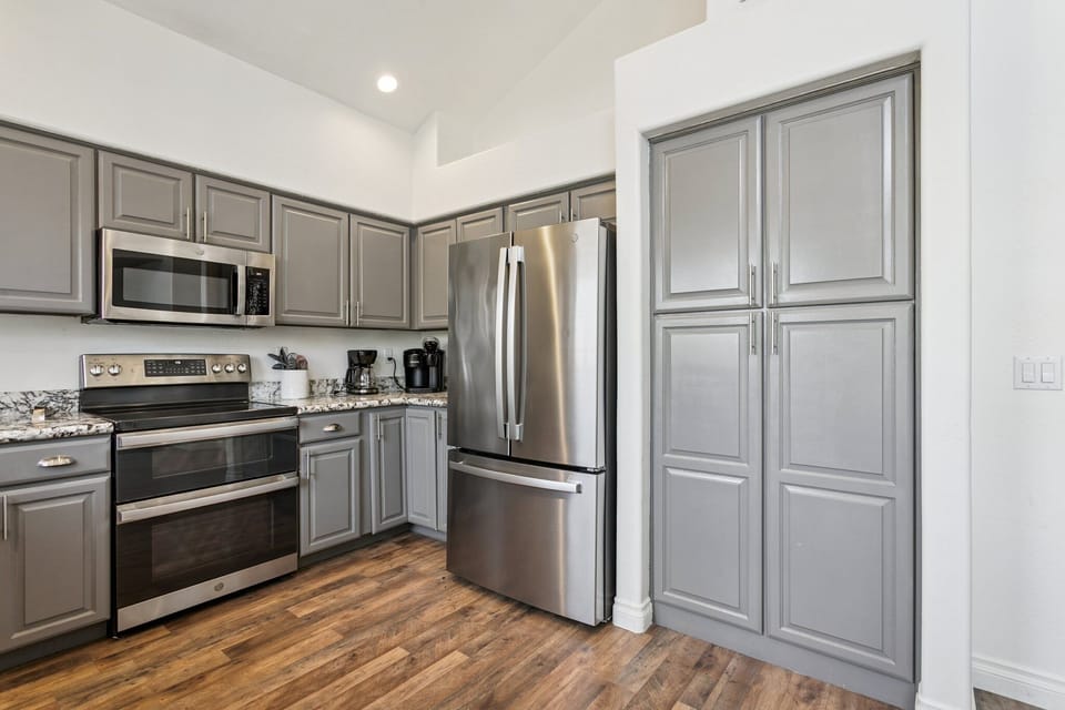 Your fully equipped kitchen features stainless steel appliances and elegant gray cabinetry, perfect for preparing memorable meals during your stay.