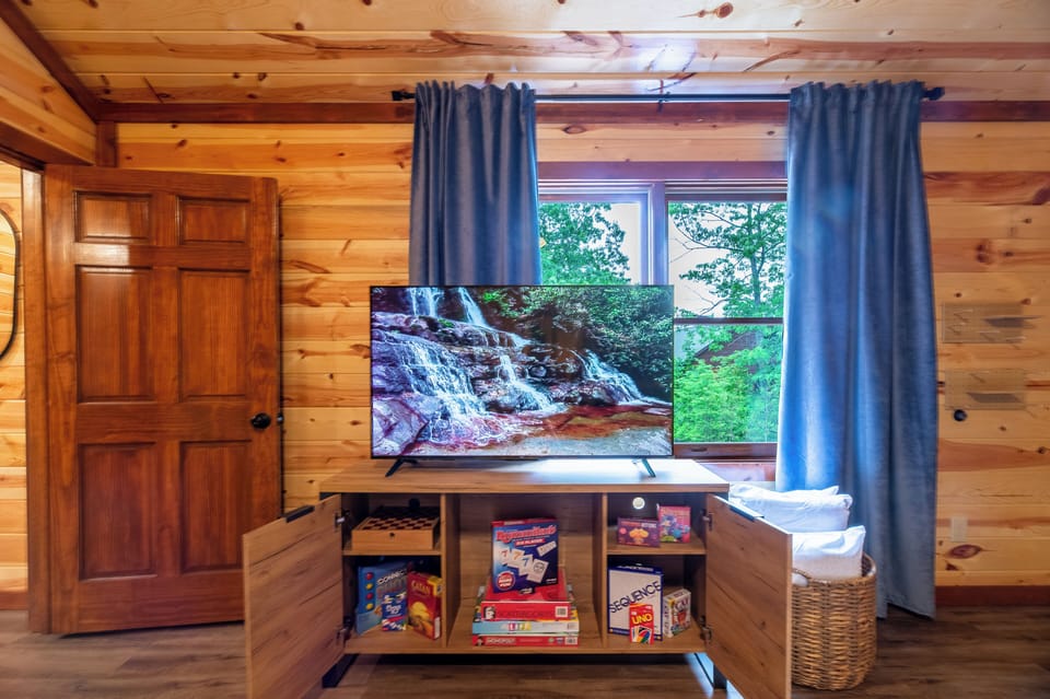 The inviting cabin living room offers plush sofas, rustic charm, and plenty of natural light—perfect for gathering after a day of adventure.