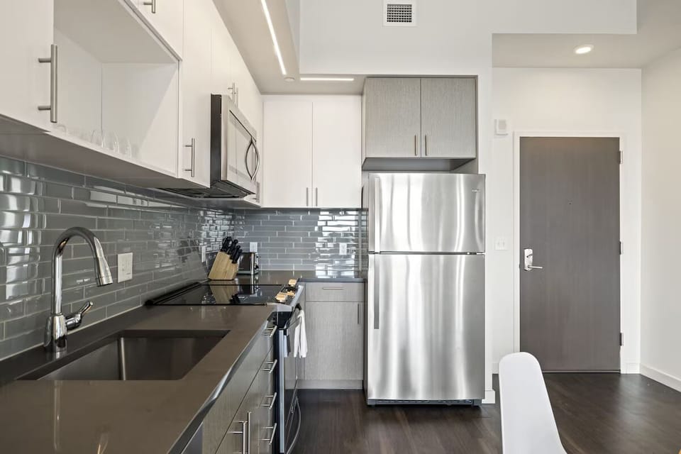 Cook effortlessly with sleek appliances and glossy tile backsplash.