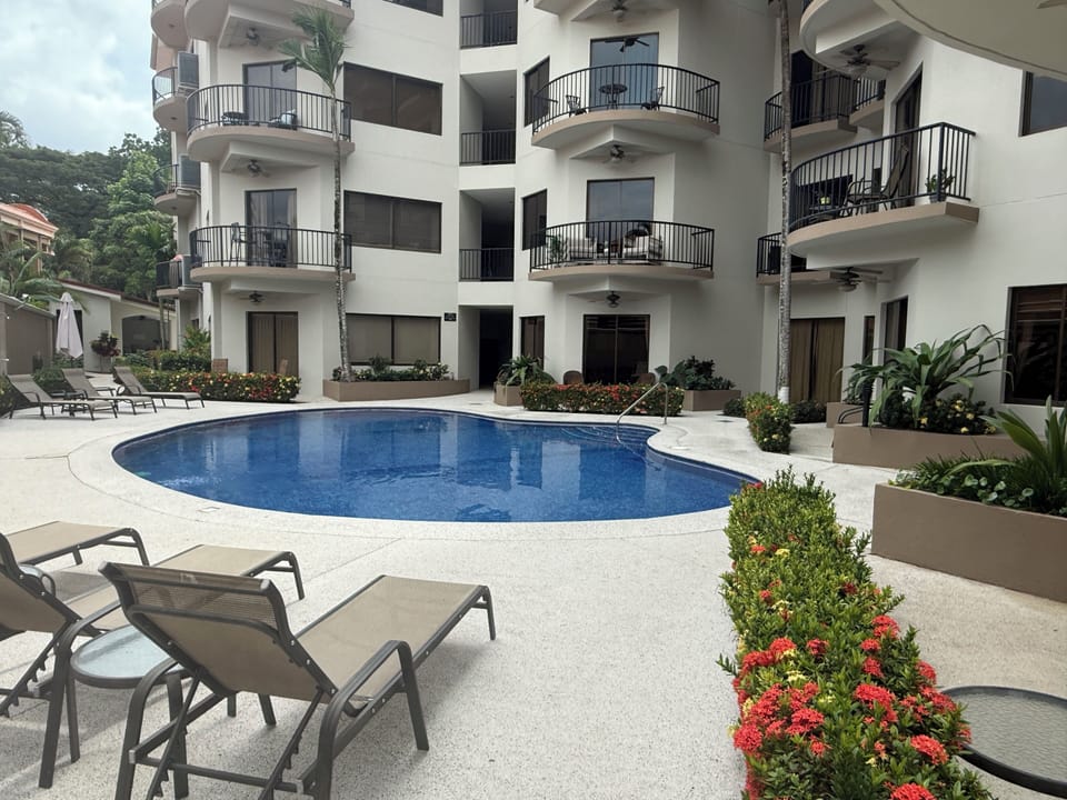 Resort-style pool with loungers in a peaceful tropical courtyard