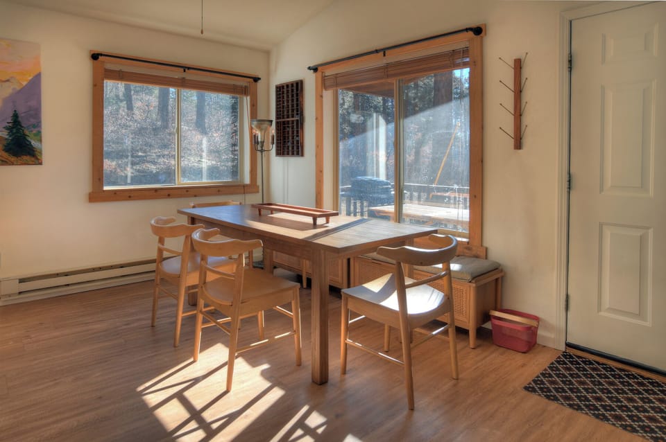 Sunny living and dining room with large windows framing mountain views – feel connected to nature while enjoying the comforts of home.