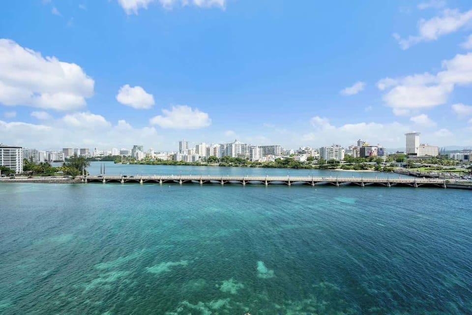 Behold the magnificent Condado Lagoon, a vibrant centerpiece of our locale. This panoramic view showcases the serene waters, lush surroundings, and the iconic bridge, inviting you to explore the beauty of San Juan from above.