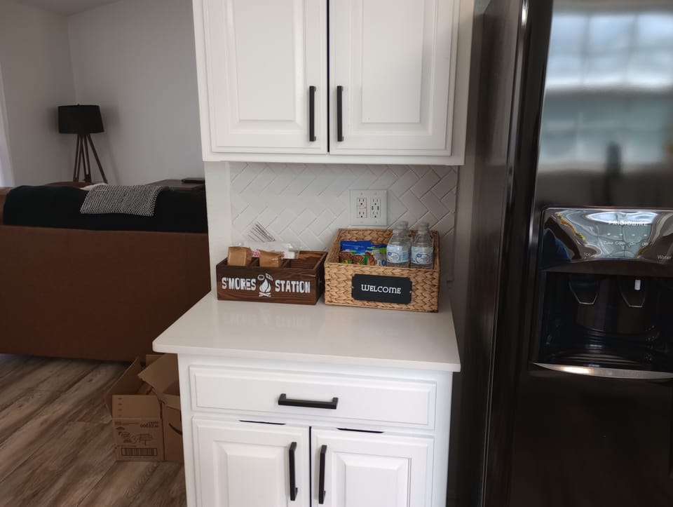 Modern bright kitchen with welcome snacks, s’mores station, and sleek fridge
