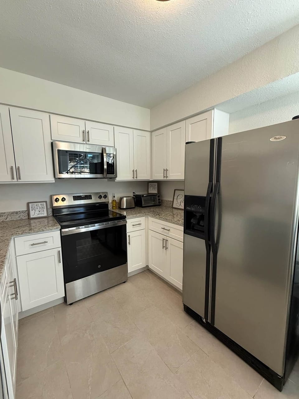 Full size kitchen with oven, stove, microwave, countertop toaster oven, refrigerator/freezer