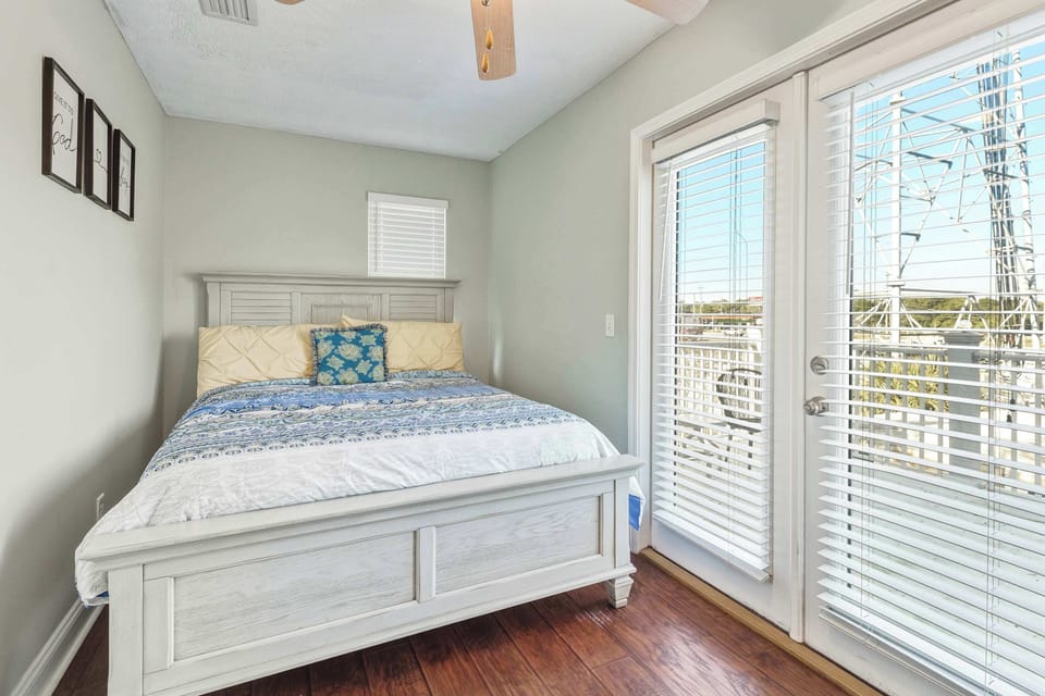 Guest bedroom with queen bed and balcony access