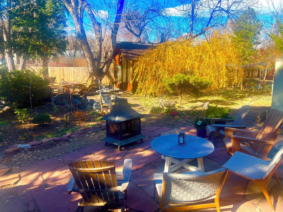 Flagstone patio next to the wooden deck, garden, and pond