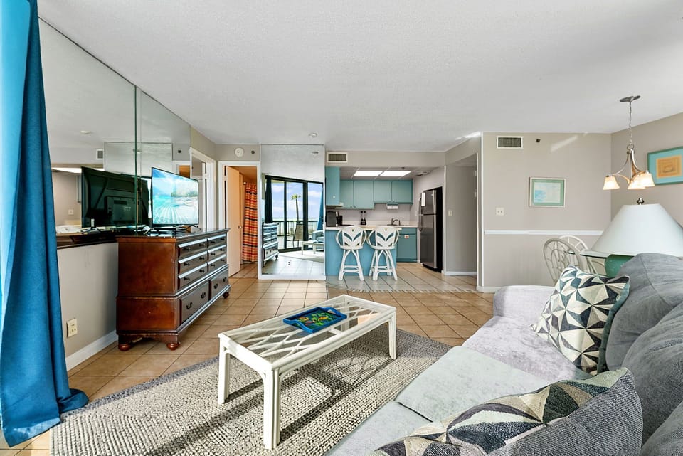 Open living area with coastal-inspired decor and a view into the kitchen.