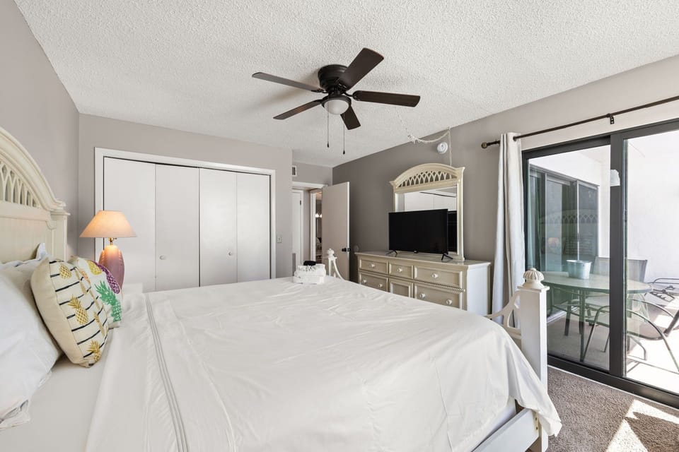 Bright bedroom with a ceiling fan and access to a private patio.