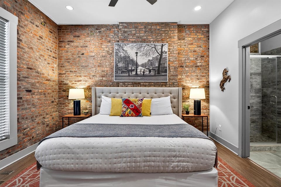 Here is another view of the sleeping area showing the symmetry of the black nightstands and lamps. The sliding barn door leads directly to the ensuite bathroom for total privacy.