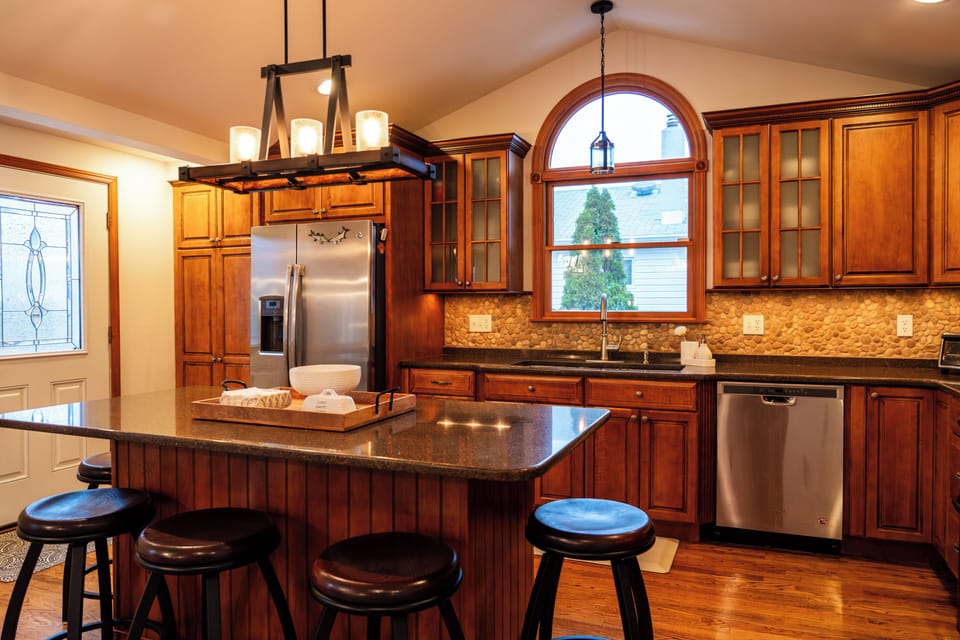 Kitchen stocked with plates, cups and silverware service for 12. Island seats 5