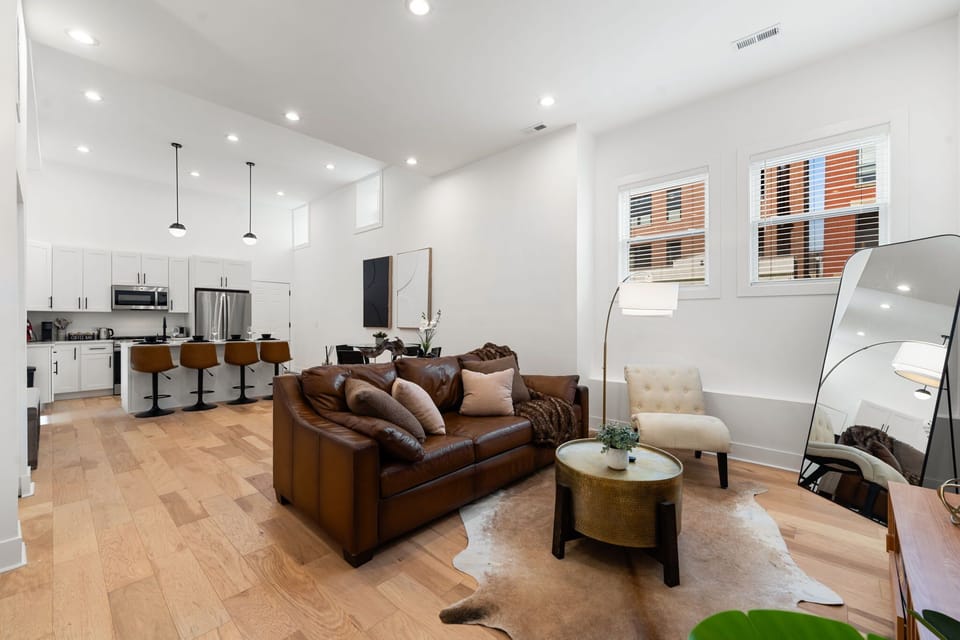 Open-concept living room w/ cozy seating & warm light for relaxed hangs.