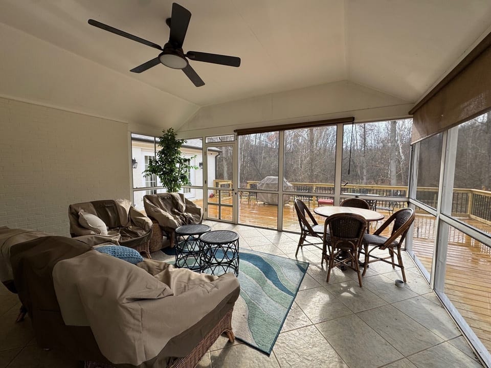 Screened in porch with patio furniture and bistro table - shows large deck
