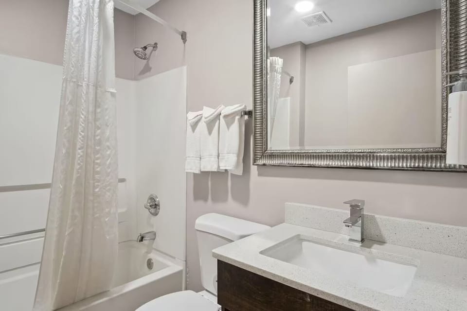 Refresh under a hot shower with bright vanity lighting.