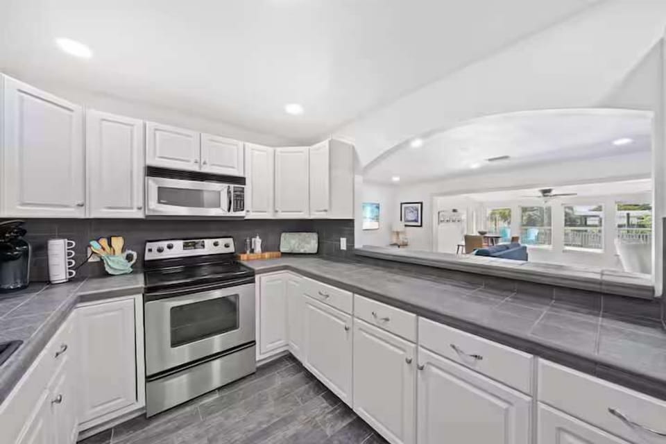 Modern kitchen with stainless steel appliances and a view into the open living area.