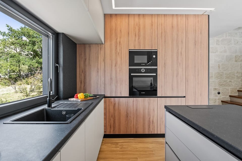 High-end built-in appliances and wood-panelled finishes offer a touch of luxury to your culinary experience.