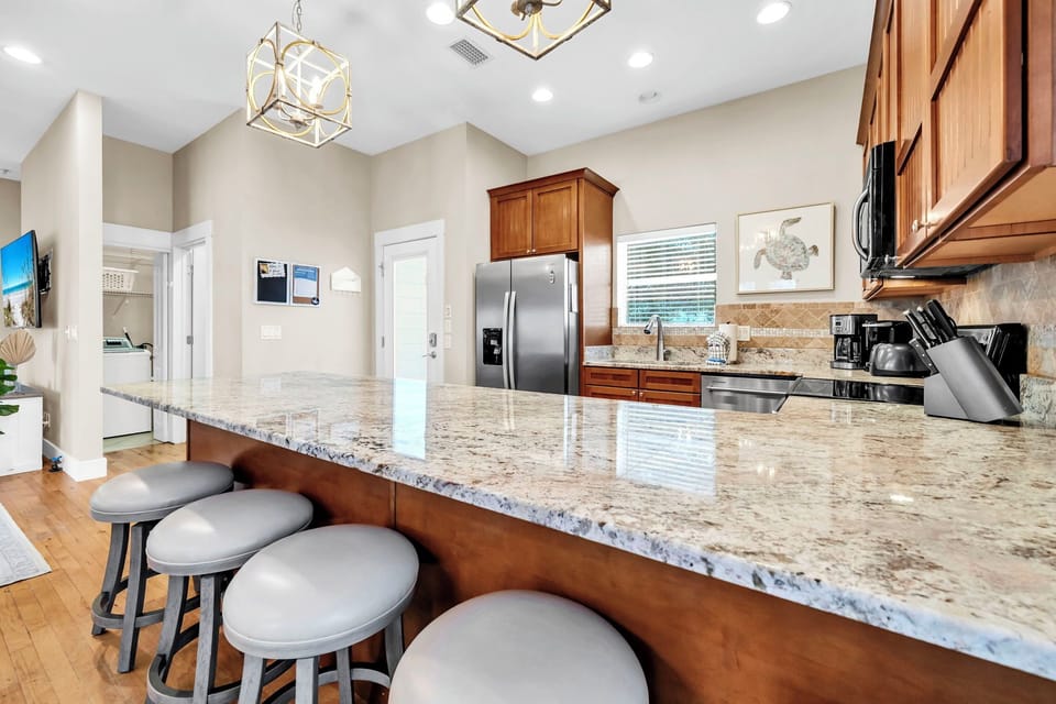 Your fully equipped kitchen features gleaming granite countertops, modern appliances, and a spacious island with seating for memorable meals together.