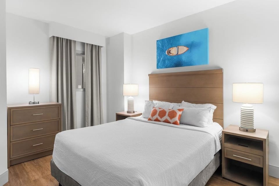Sink into a serene king bed with warm bedside glow.
