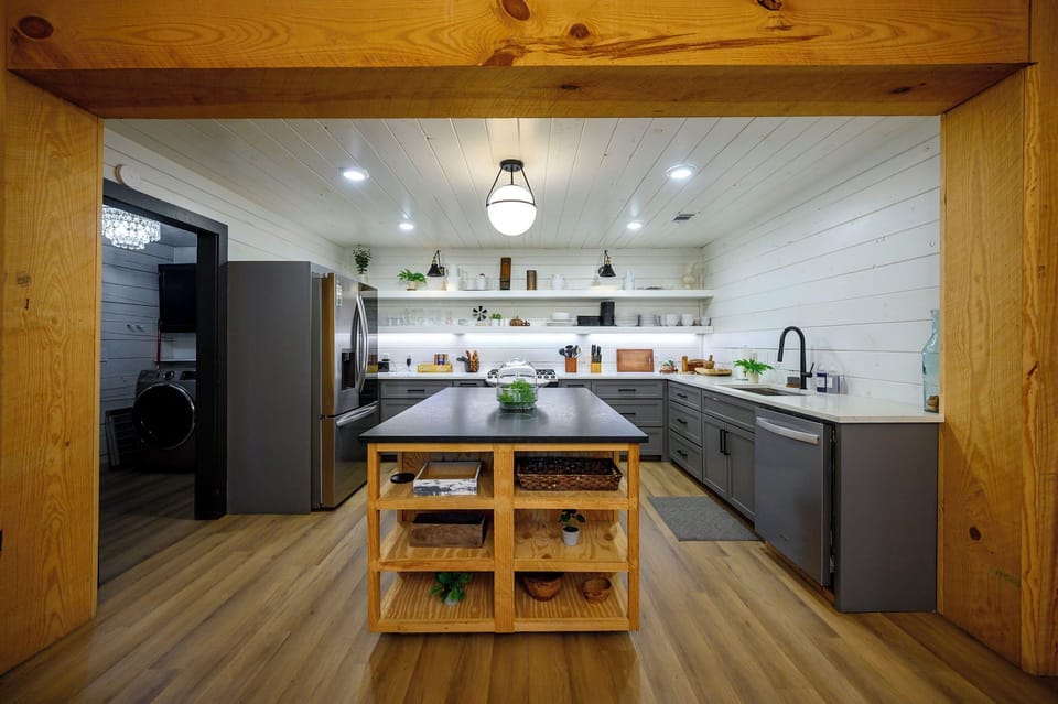 Step into your chef's paradise with sleek gray cabinetry, spacious island, and modern appliances - perfect for creating memorable meals together.