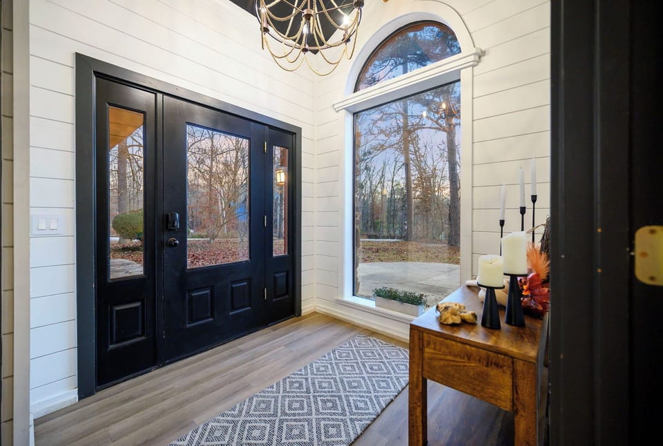 Step into your elegant entryway with soaring ceilings, gorgeous shiplap walls, and beautiful natural light streaming through arched windows.