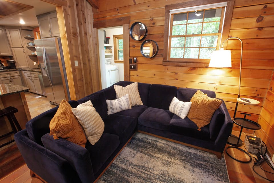 Sink into the deep sectional with plush pillows and 50" Roku TV on the wall.