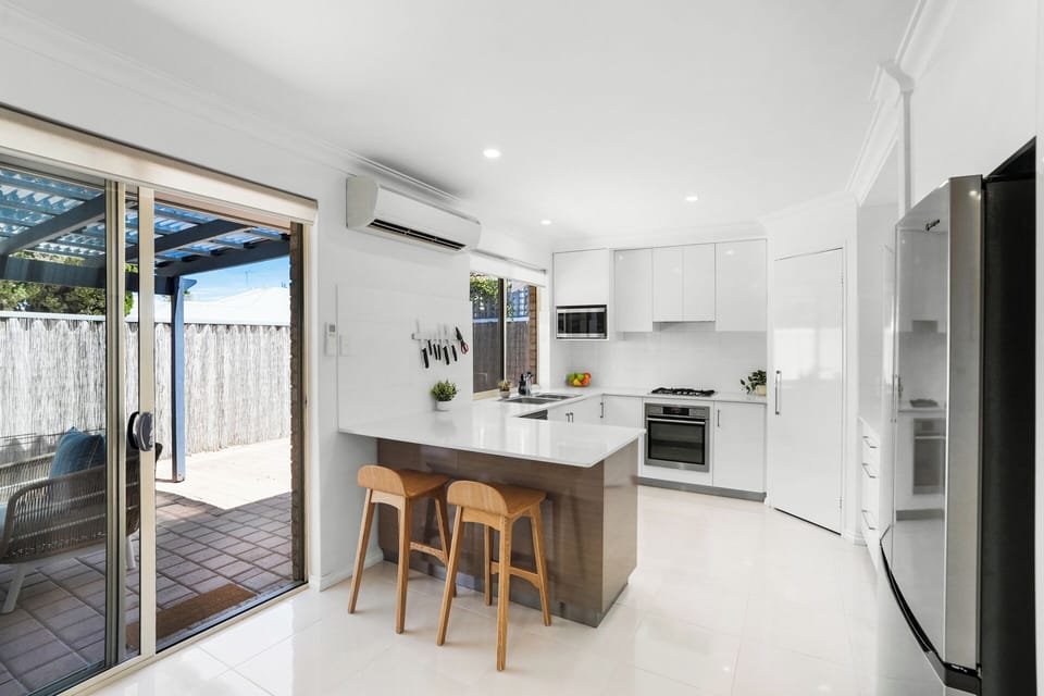 Modern kitchen with island seating and outdoor access.