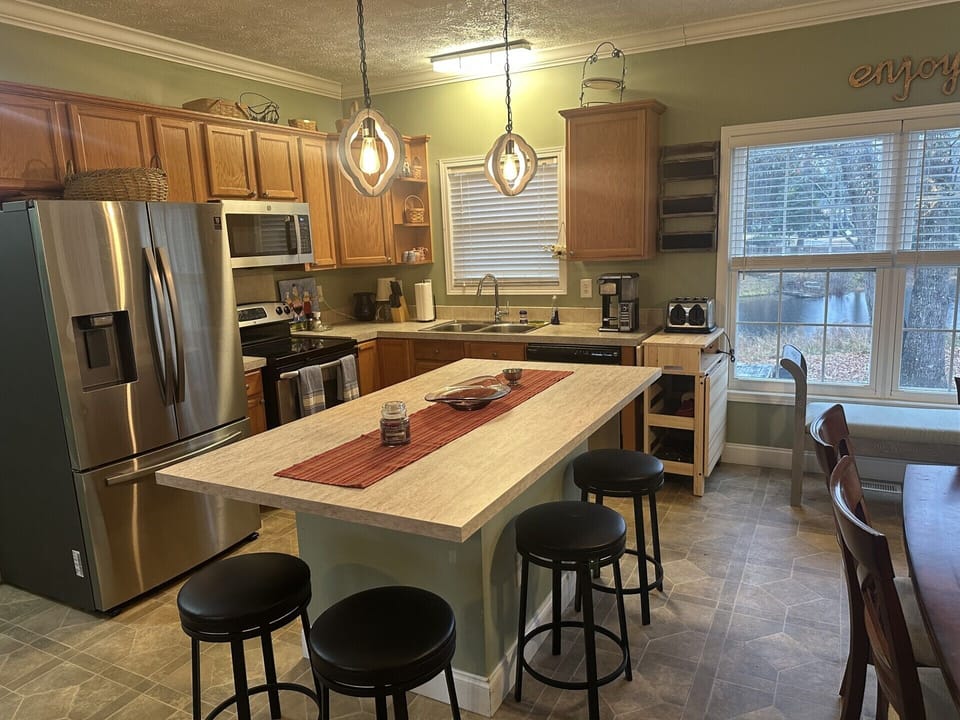 Fully stocked kitchen with range, microwave, dishwasher, air fryer, and island