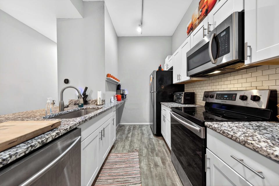 Elevate your cooking experience in this beautifully appointed kitchen, complete with modern stainless steel appliances and luxurious granite countertops. 