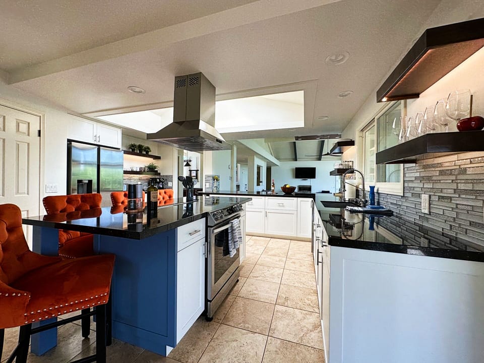 Open concept villa gourmet kitchen with countertop leading into living room
