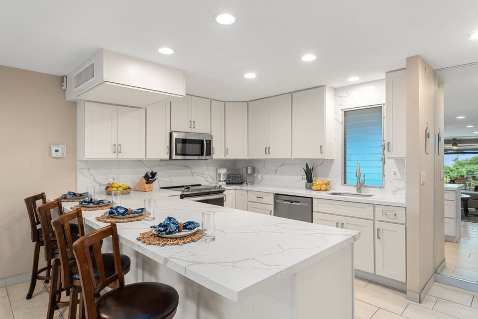 Modern kitchen featuring a large island breakfast bar, stylish stools, and ample space for cooking and entertaining.