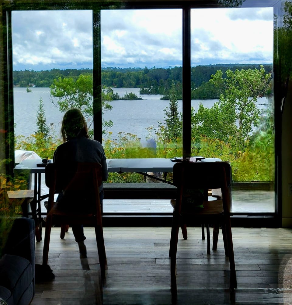 Dining area with floor-to-ceiling windows overlooking Lake Vermilion.