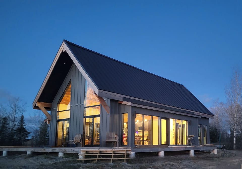Brand-new bluff top cabin glowing at dusk above Lake Vermilion.