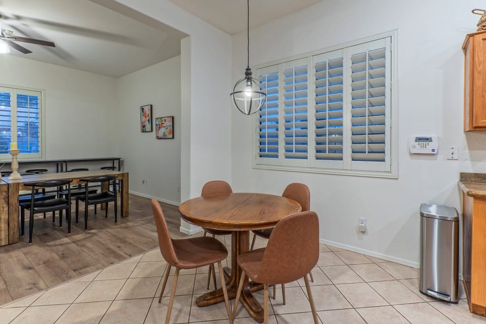 Kitchen with island and eating area opens into modern dining area with table and bar seating.
