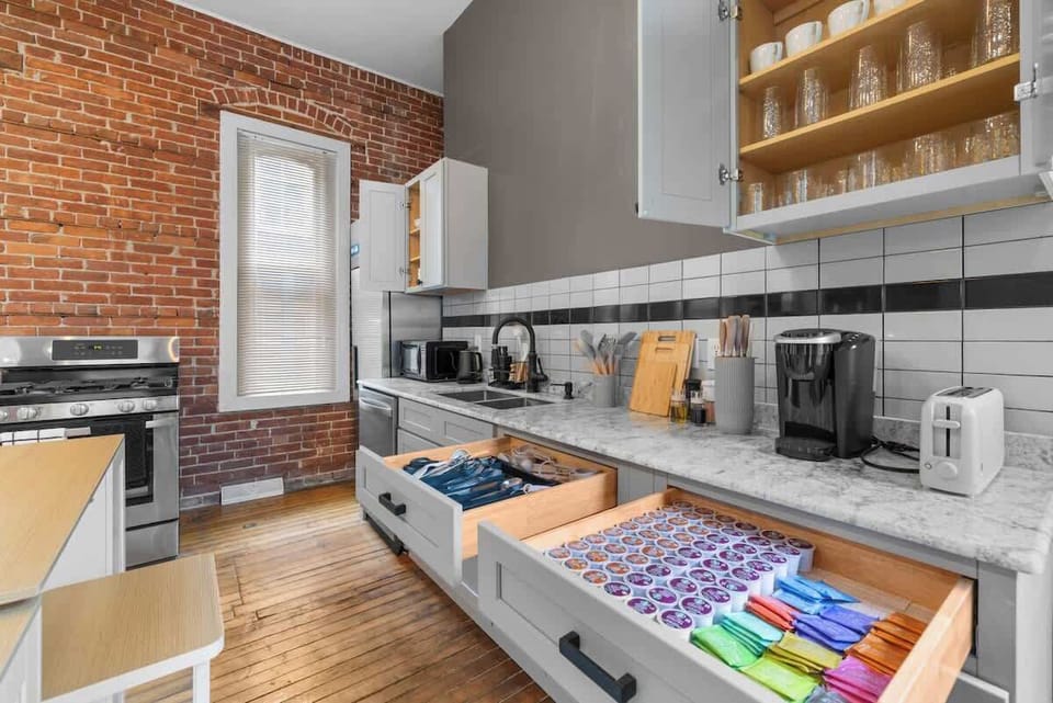Our elegant, open-plan kitchen and dining area is the heart of the home, boasting historic brick accents and plenty of natural light.