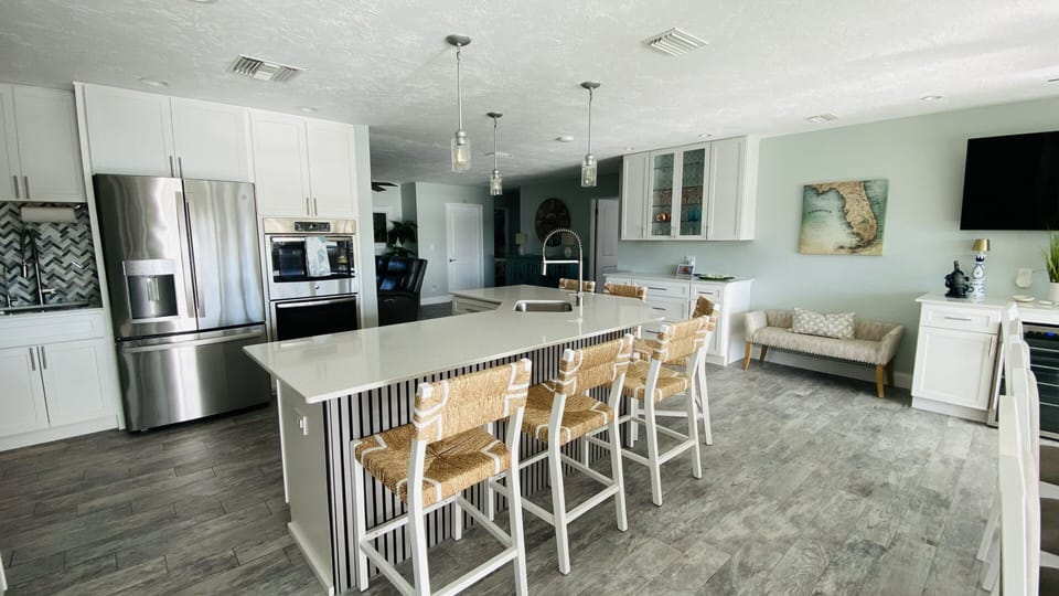 Bright coastal kitchen: quartz island for 5, bar nook, stainless appliances