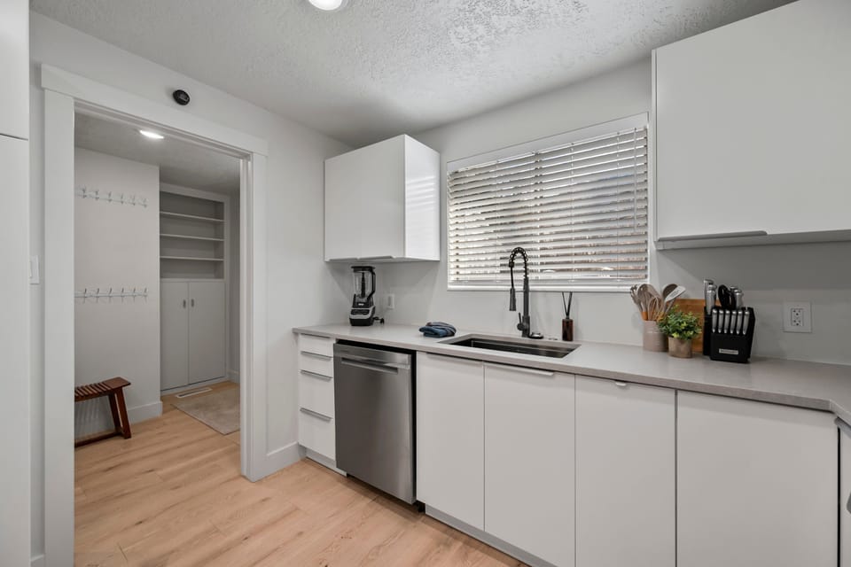 A large kitchen with lots of counter top space, modern stainless steel appliances and fully stocked with many modern conveniences