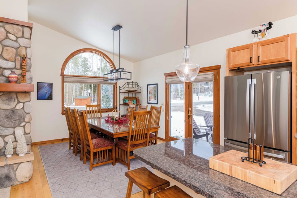 Gather around this inviting dining table where natural light streams through arched windows, creating the perfect setting for memorable meals together.