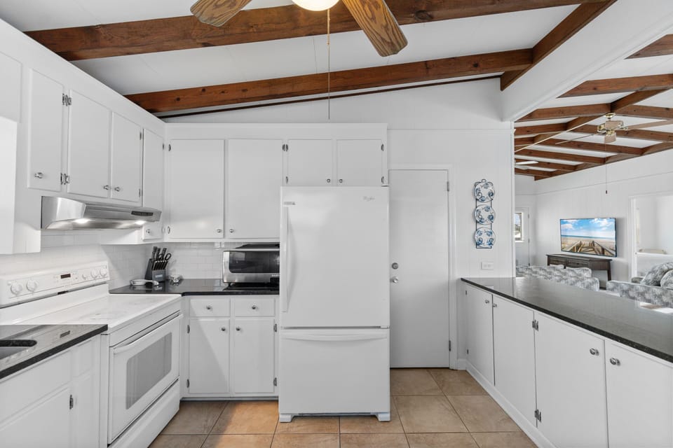Your fully-equipped kitchen features stunning exposed wood beams overhead, creating rustic charm while you prepare meals in this bright, airy space.
