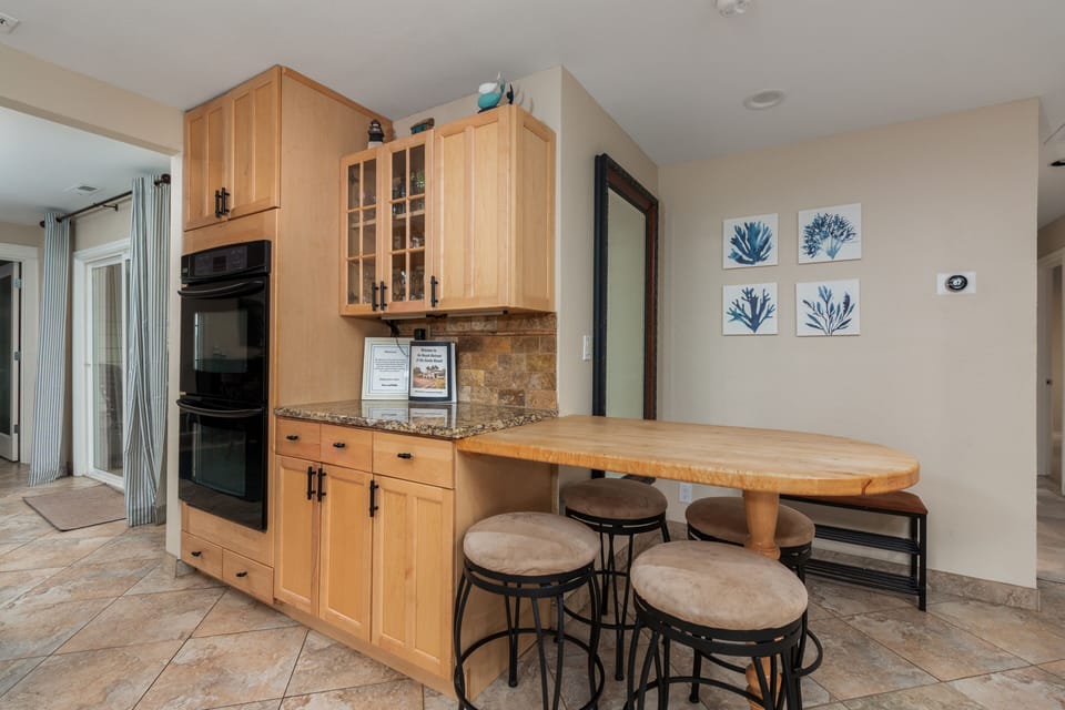 Your spacious kitchen features warm wood cabinetry, granite countertops, and a breakfast bar where you can start each morning with coffee.